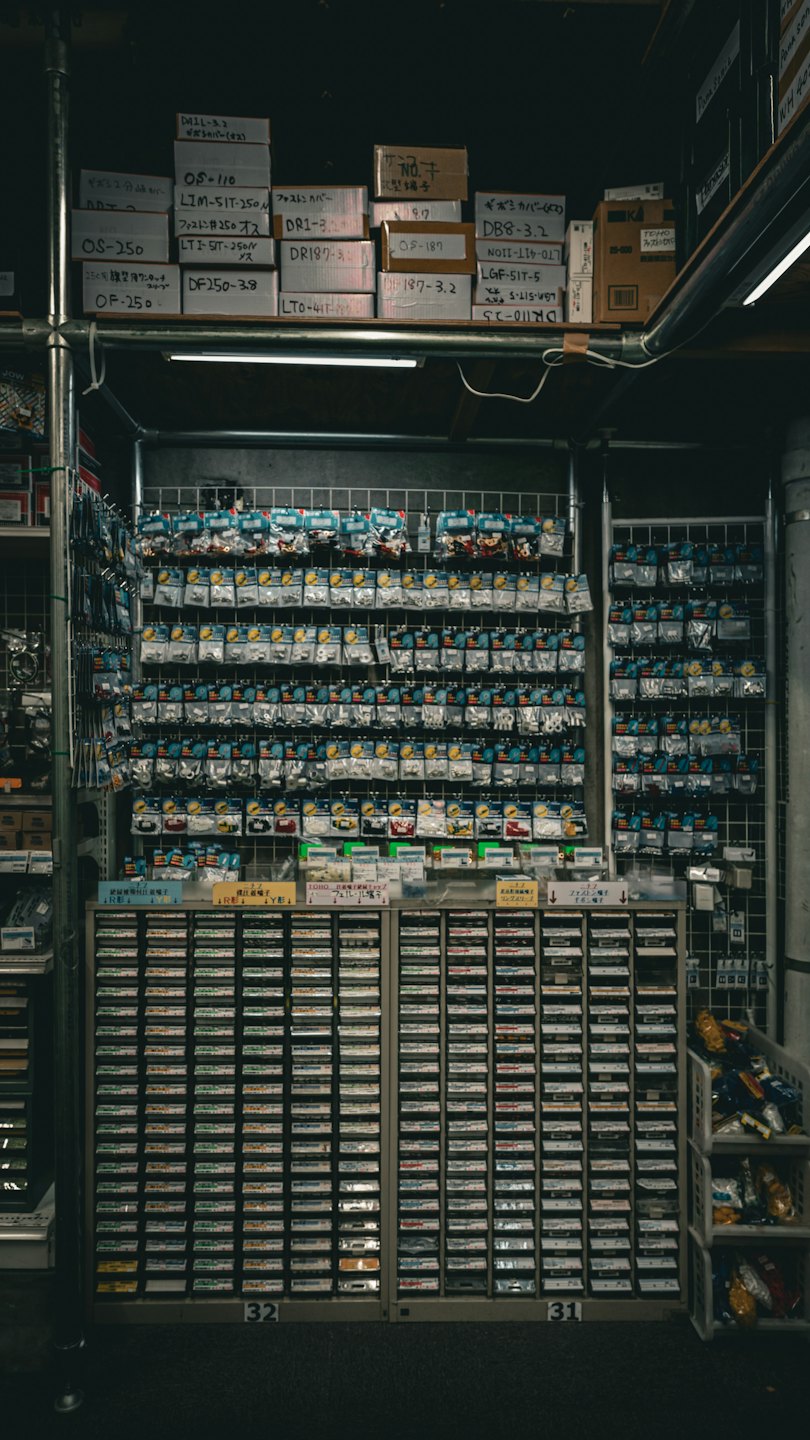 Small electronic parts organized in plastic bags on a grid wall.